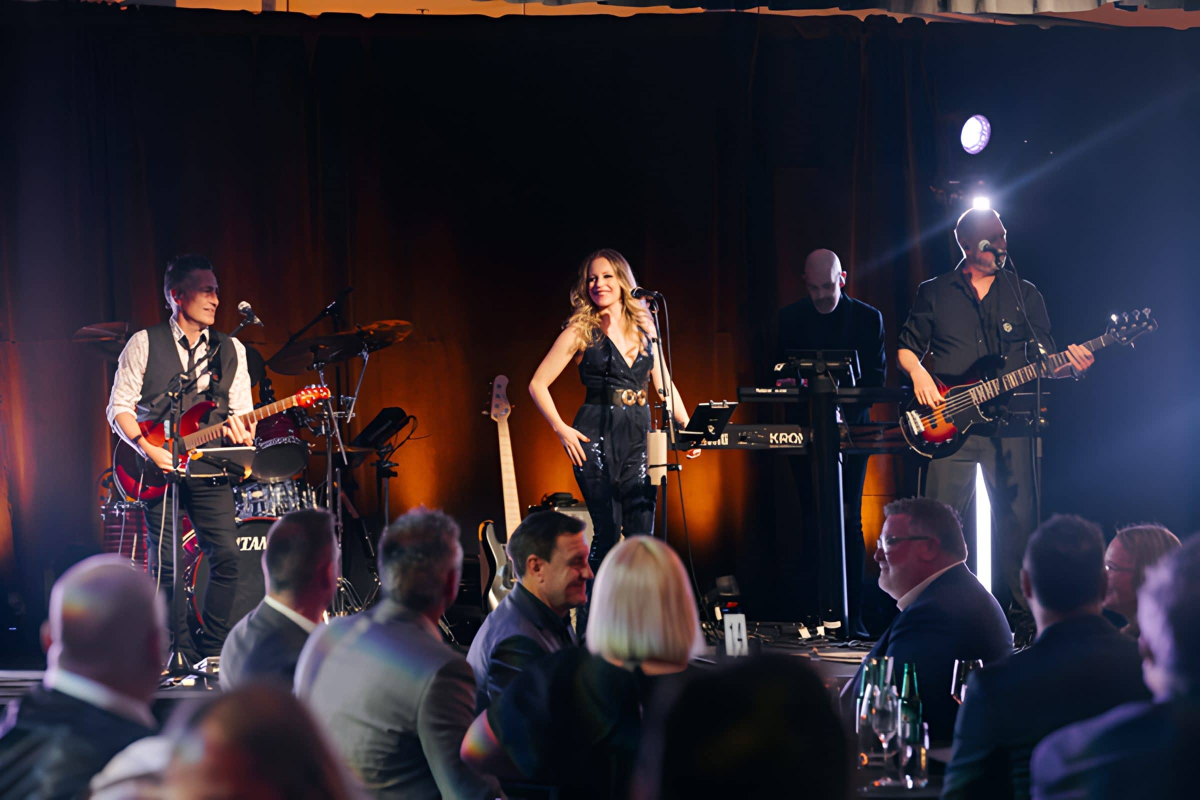 Hands Off on stage at a corporate awards dinner, guests watching from their tables